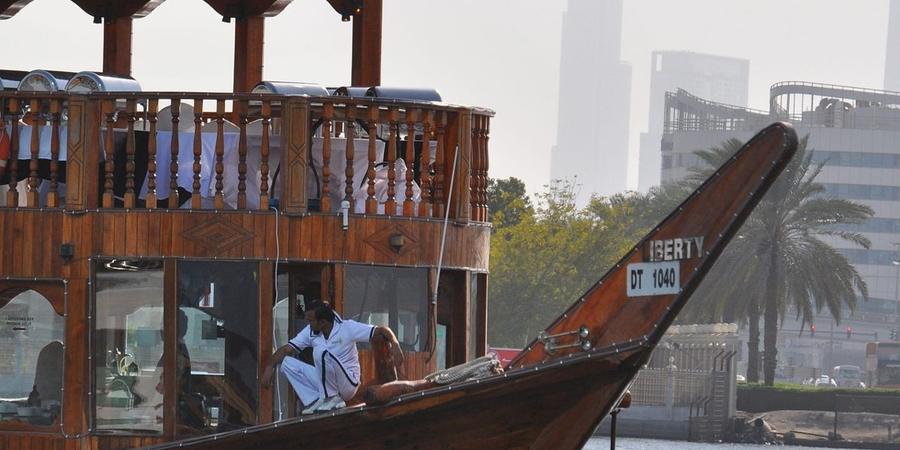 A wooden dhow on Dubai Creek with Burj Khalifa hazy behind; Dubai Healthcare City sits on the creek at Oud Metha (representative view)
