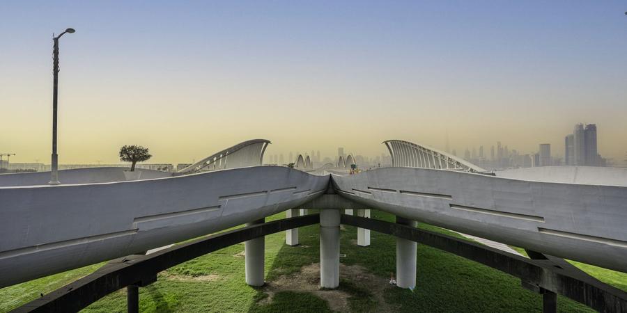 The Meydan bridge at dusk with the Downtown skyline behind